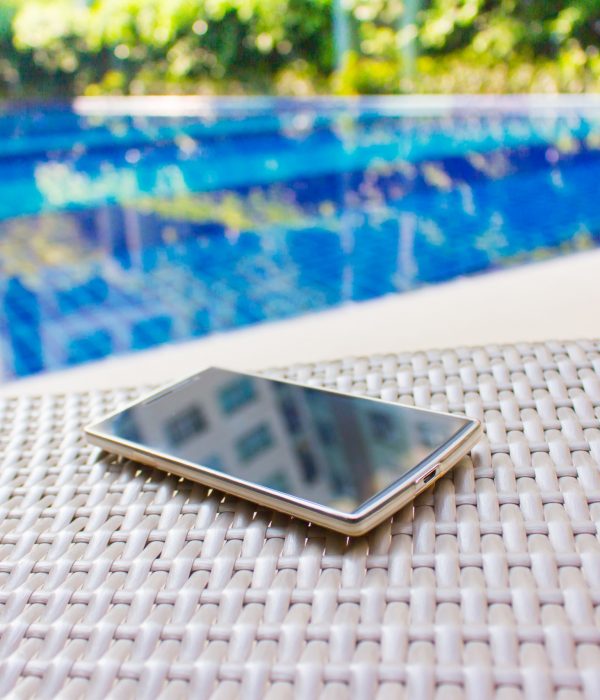 Smartphone put on armchair beside the pool means to get resting  away from business